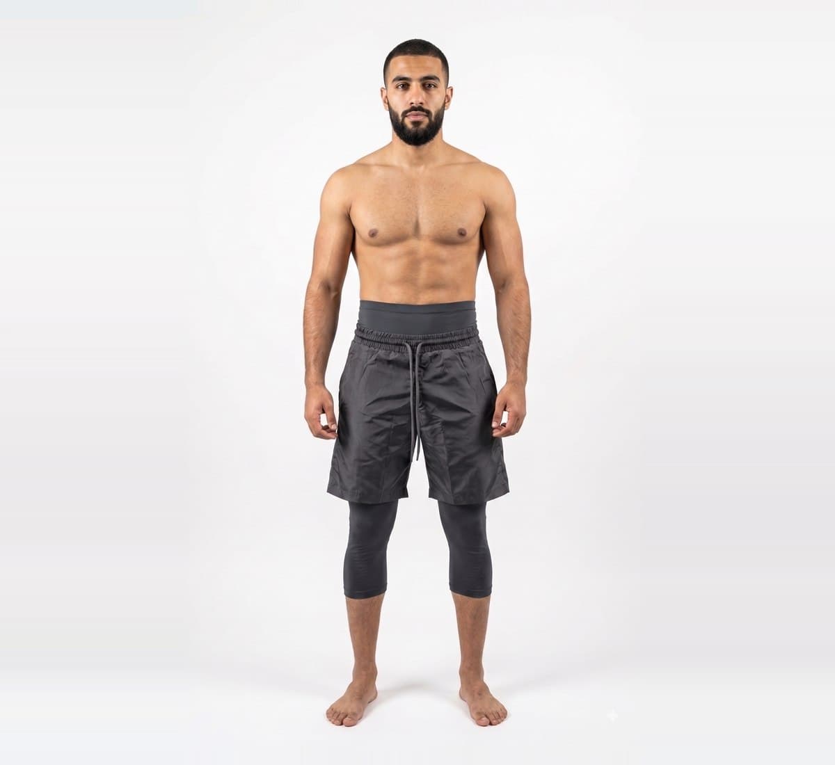 The waist and leg of the Awrah Training Short in Charcoal, showing the outer short over the attached legging